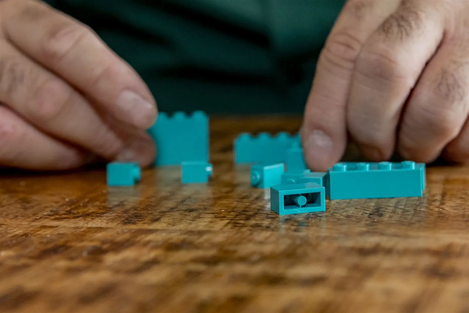 Handen die samen met LEGO-blokjes bouwen